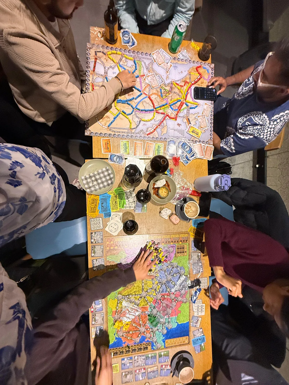 Friends gathered around tables playing board games together